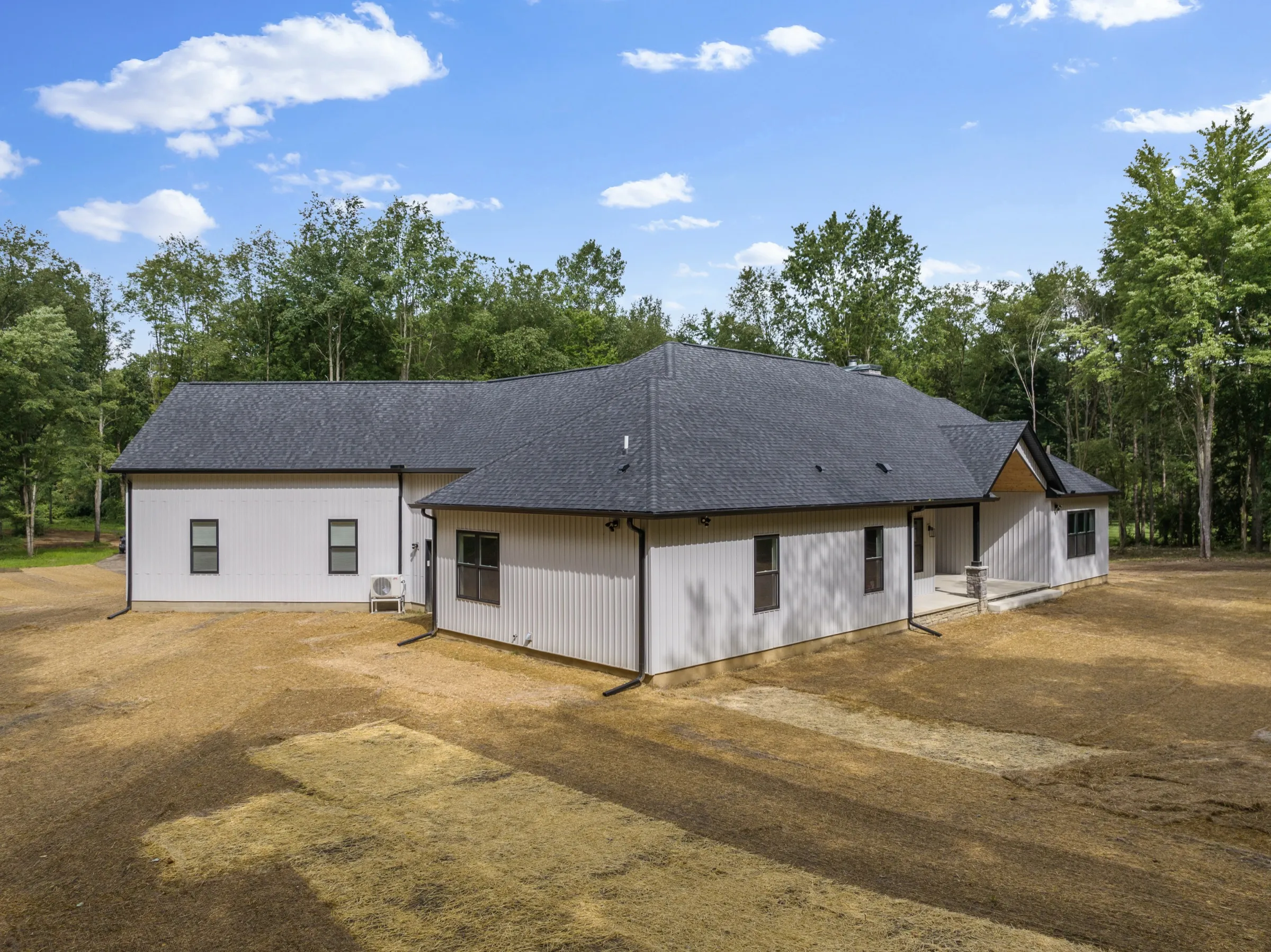 Aerial view of the rear and side elevations across the graded lot.